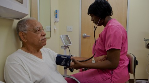 Nurse checking a elderly man's blood pressure