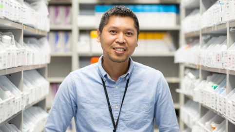 worker standing in a pharmacy stock room.