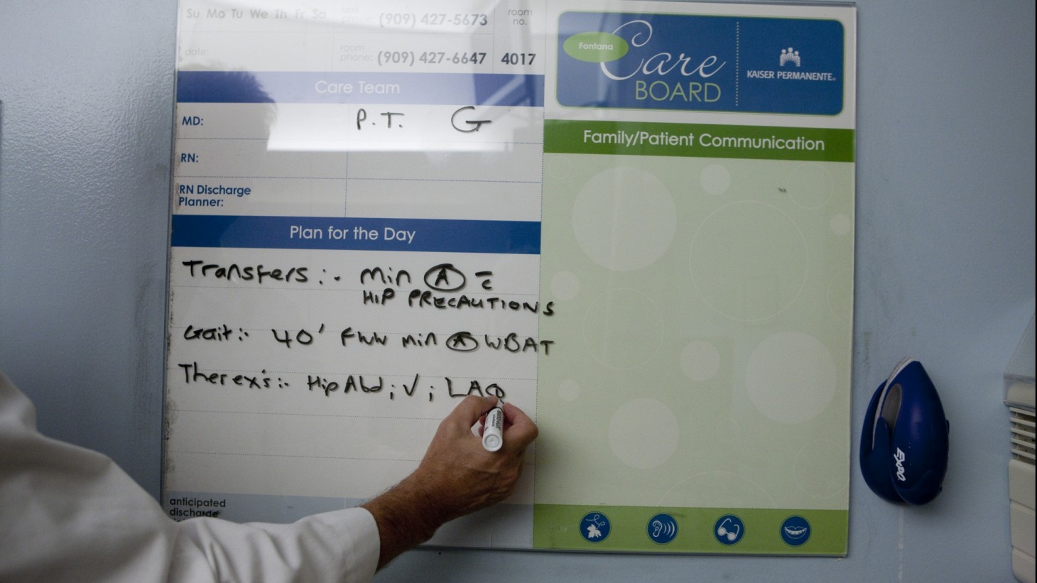 a hand writing on a whiteboard