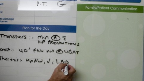 a hand writing on a whiteboard