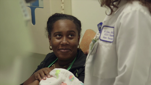 Mother with baby and care provider in the NICU